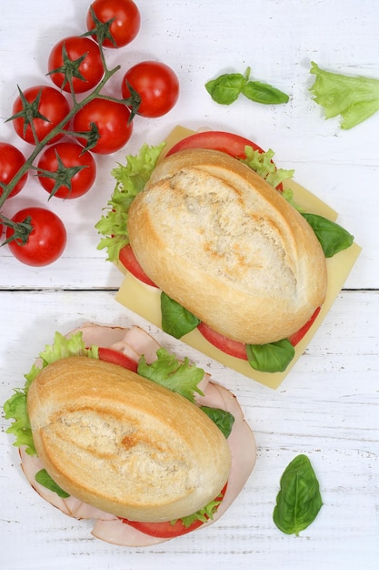 Sándwich de baguette con jamón y queso desde arriba en formato vertical sobre tabla de madera