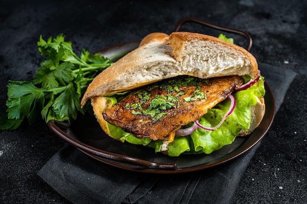 Sandwich Balik Ekmek mit gegrilltem Makrelenfilet, Tomaten, Zwiebeln und Salat Schwarzer Hintergrund Ansicht von oben