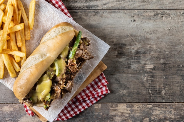 Sándwich de bistec con queso de Filadelfia en mesa de madera Sándwich tradicional de Filadelfia