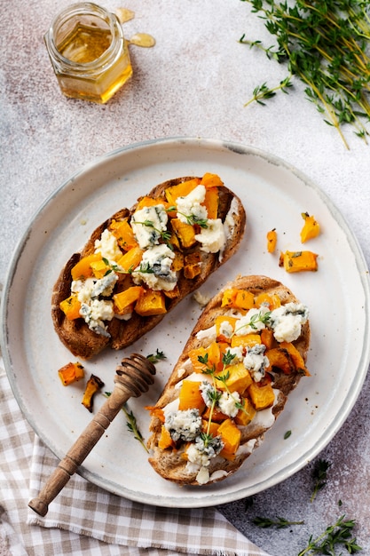 Sandwich de calabaza al horno con queso dorblu con moho azul y tomillo sobre un fondo de hormigón