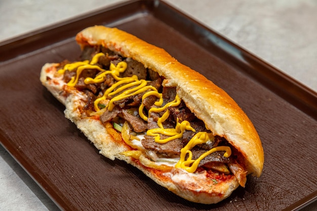 Un sándwich de carne de res con mostaza para hacerle agua a la boca.