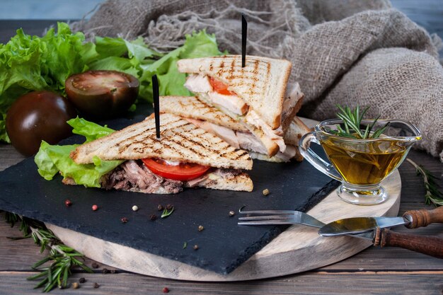 Sándwich con carne y verduras frescas en una mesa de madera