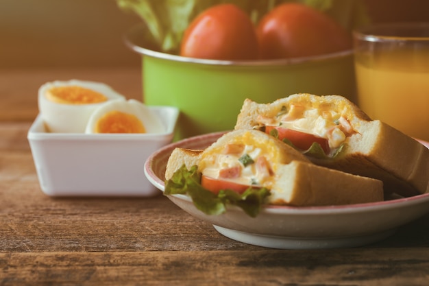 Sándwich casero con huevos duros y mayonesa decorada con lechuga y tomate