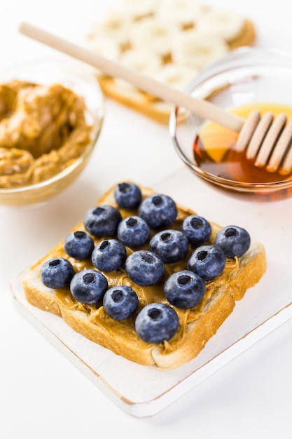 Sándwich casero de mantequilla de maní y arándanos en pan blanco.