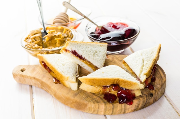 Sándwich casero de mantequilla de maní y mermelada en pan blanco.