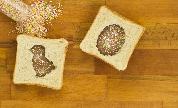 Sándwich con chocolate en forma de conejo y huevos sobre un fondo de madera Almuerzo festivo para niños