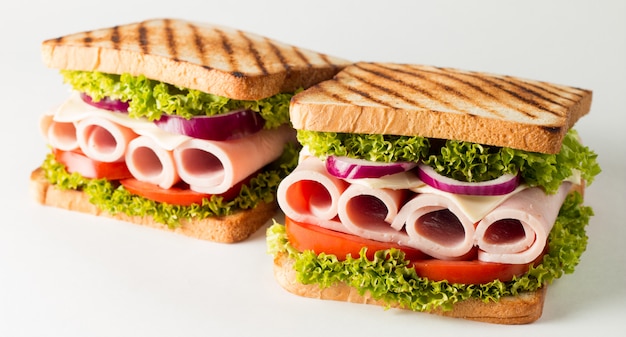 Un sándwich club con carne, ensalada, verduras.