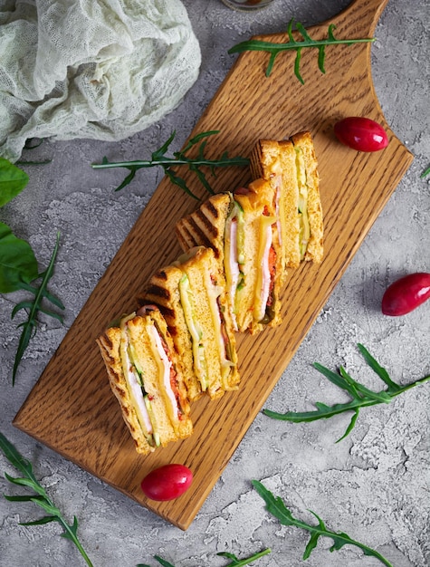 Sándwich club con jamón, queso, tomate y ensalada Sándwich a la plancha con pan de tomates secos