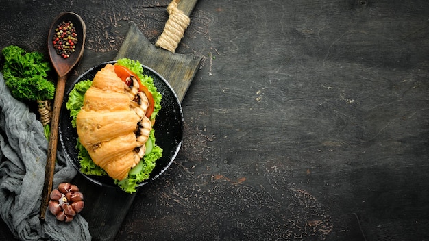 Sándwich de croissant de desayuno con champiñones, tomates y cebollas Vista superior Espacio libre para el texto