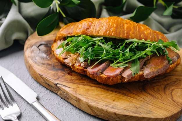 Sándwich de croissant gourmet con rúcula y jamón