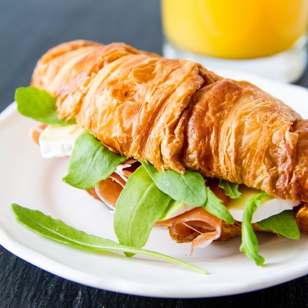 Sándwich de croissant con jamón y rúcula brie