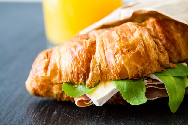 Sándwich de croissant con jamón y rúcula brie