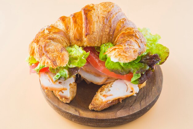 Sandwich de croissant de lechuga, tomate y pavo ahumado