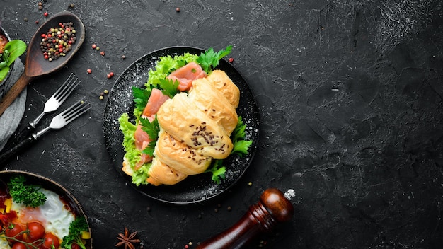 Sandwich-Croissant mit Lachs, Tomaten und Zwiebeln. Frühstück. Ansicht von oben. Freiraum für Ihren Text.