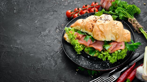 Sándwich Croissant con salmón tomates y cebollas Desayuno Vista superior Espacio libre para su texto