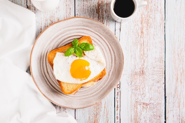 Sándwich de croque madame con queso de jamón y huevo en un plato en la vista de la mesa