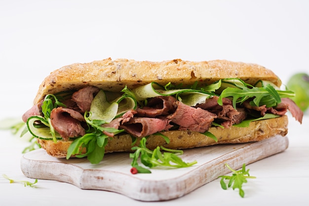 Sandwich des Vollweizenbrotes mit Roastbeef, Gurke und Arugula