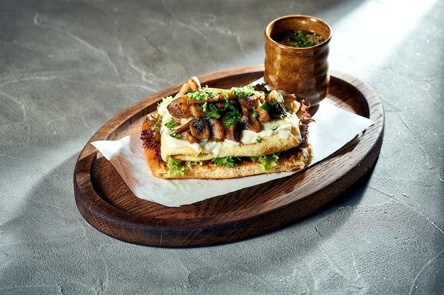 Sándwich de desayuno con tortilla y champiñones y salsa blanca Fondo de hormigón Luz dura Comida vegetariana