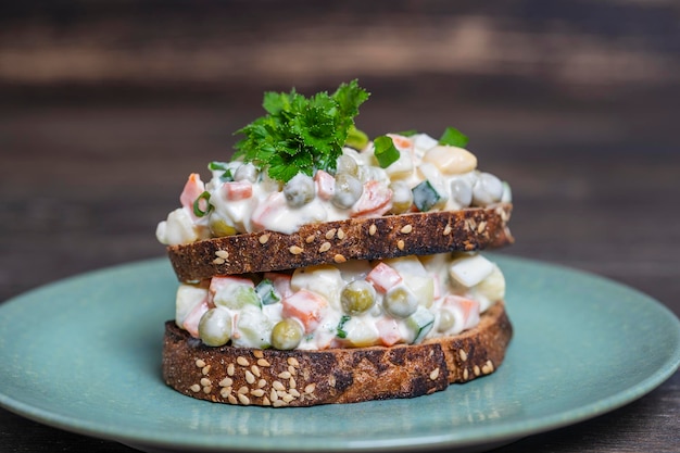 Sándwich doble casero saludable con ensalada olivier en plato listo para comer comida ucraniana