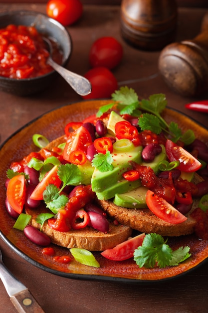 Sandwich de frijoles de aguacate mexicano con cebolleta y tomate picante