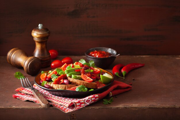 Foto sándwich de frijoles de aguacate mexicano con cebolleta y tomate picante