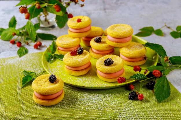 Sandwich de galletas de limón con frutos rojos y negros. De cerca.