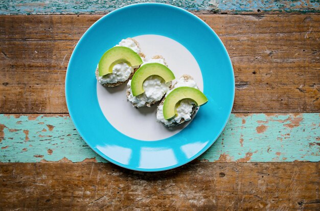 Sandwich gesundes Brot mit Samen mit Frischkäse und Avocado auf dem Teller auf dem Tisch