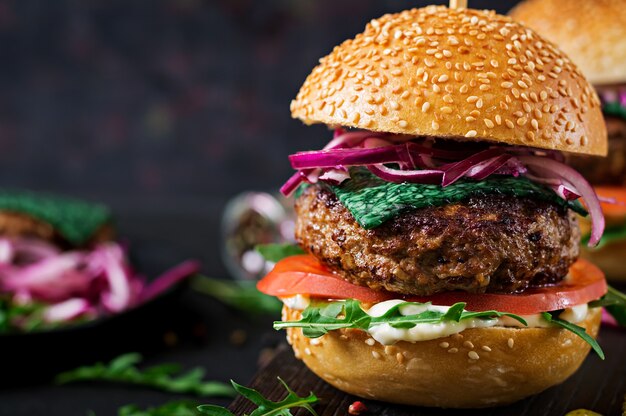 Sándwich grande - hamburguesa con carne de res, tomate, queso de albahaca y rúcula.