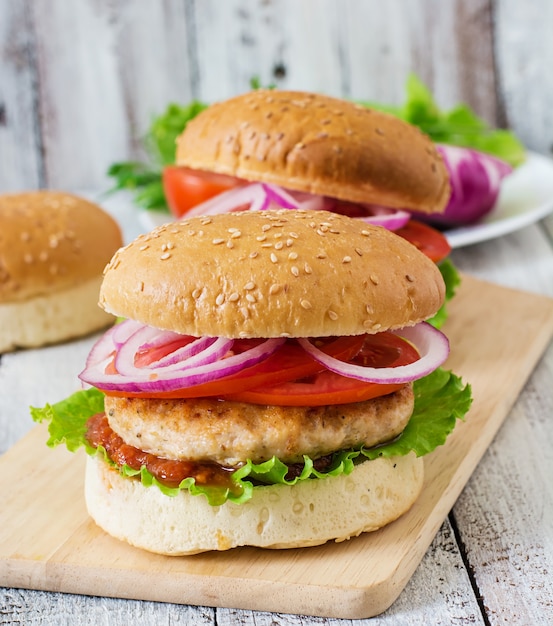 Sandwich con hamburguesa de pollo, tomate, cebolla morada y lechuga