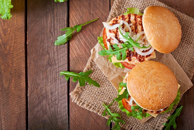 Sandwich con hamburguesa de pollo, tomate, queso y lechuga.