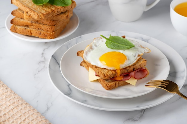 Sándwich con huevo frito tocino queso y espinacas