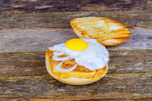 Sándwich de huevo frito, tocino, queso y verduras.