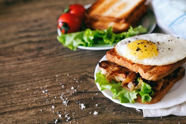 Sándwich con huevos pollo pepino y lechuga sobre un fondo de madera Espacio de copia de enfoque selectivo