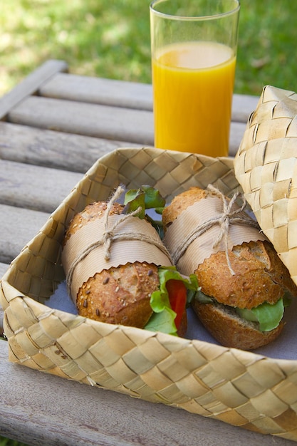 Sandwich in einem Korb mit Orangensaft