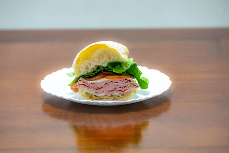 Foto sándwich italiano de mortadella bologna con tomate de rúcula y queso en pan de ciabatta
