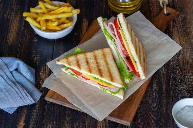 Sándwich de jamón, ensalada, tomate y queso. Cocina americana. Comida rápida.