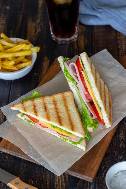 Sándwich de jamón, ensalada, tomate y queso. Cocina americana. Comida rápida.