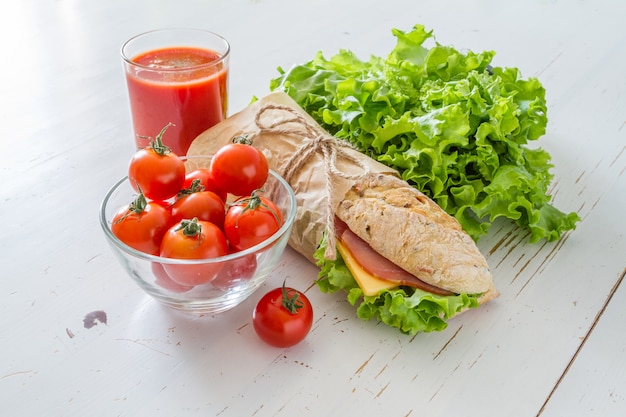 Sándwich de jamón con queso, ensalada y tomates.