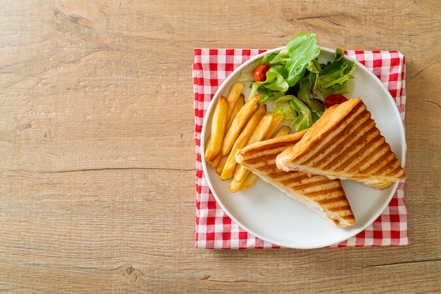 Sándwich de jamón y queso con huevo y patatas fritas