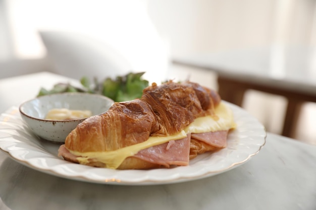 Sándwich de jamón y queso en mesa blanca en cafetería