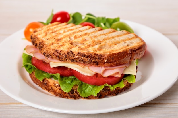 Sandwich de jamón y queso tostado en la mesa de madera