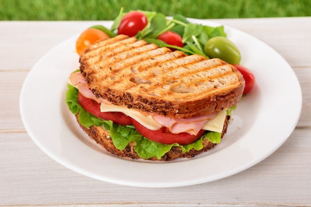 Sandwich de jamón y queso tostado en la mesa de madera