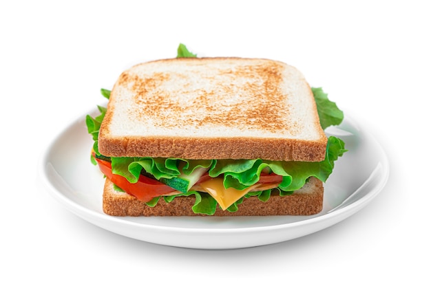 Sándwich de jamón, queso, verduras y ensalada en un plato sobre un fondo blanco. Vista lateral.