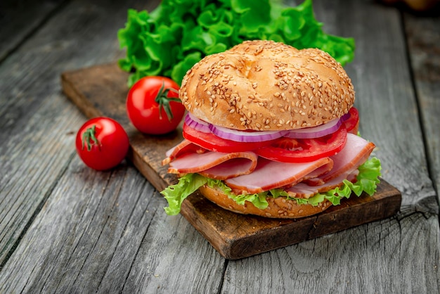 Sándwich de jamón y verduras en una mesa de madera antigua