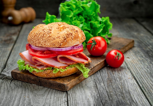 Sándwich de jamón y verduras en una mesa de madera antigua