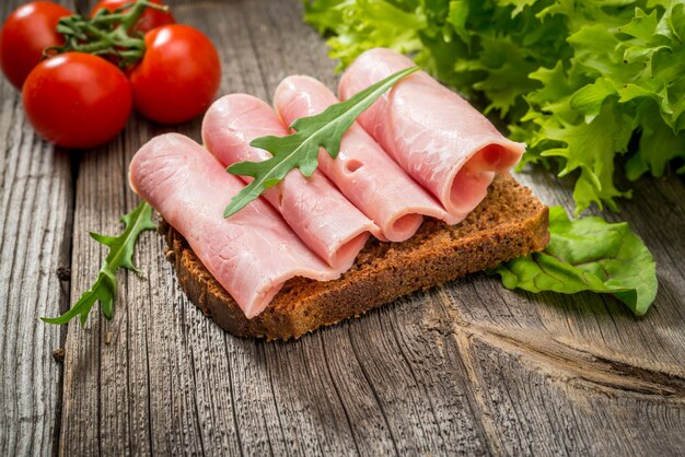 Sandwich con jamón y verduras. Productos organicos en una mesa de madera