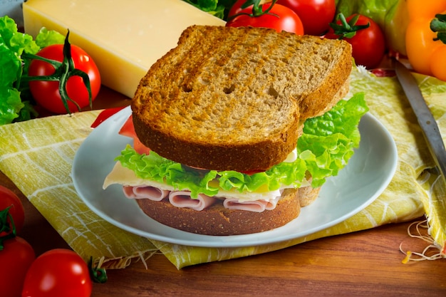 Un sándwich con lechuga y tomates en un plato.