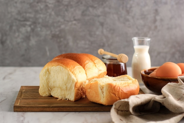 Sandwich-Milchbrot, in Stücke geschnitten, auf grauem Hintergrund. Werbeflyer für Hokkaido Milk Loaf. Japanisches Weißbrot-Banner. Hausbacken