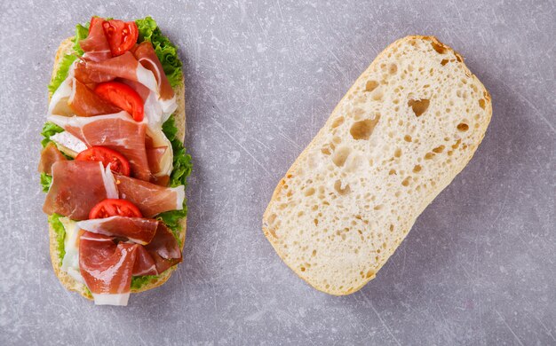 Sandwich mit Ciabatta, Prosciutto, Brie-Käse und Salat