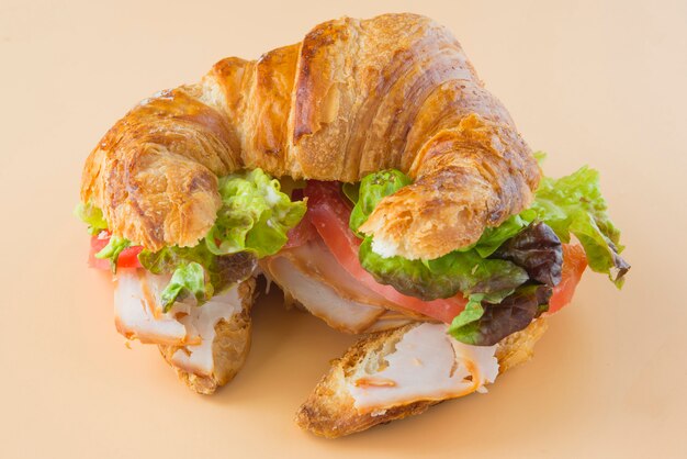 Sandwich mit Croissant aus Salat, Tomate und geräuchertem Truthahn